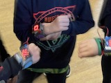 children showing their Rock Paper Scissors wristbands made in an OurKidsCode workshop